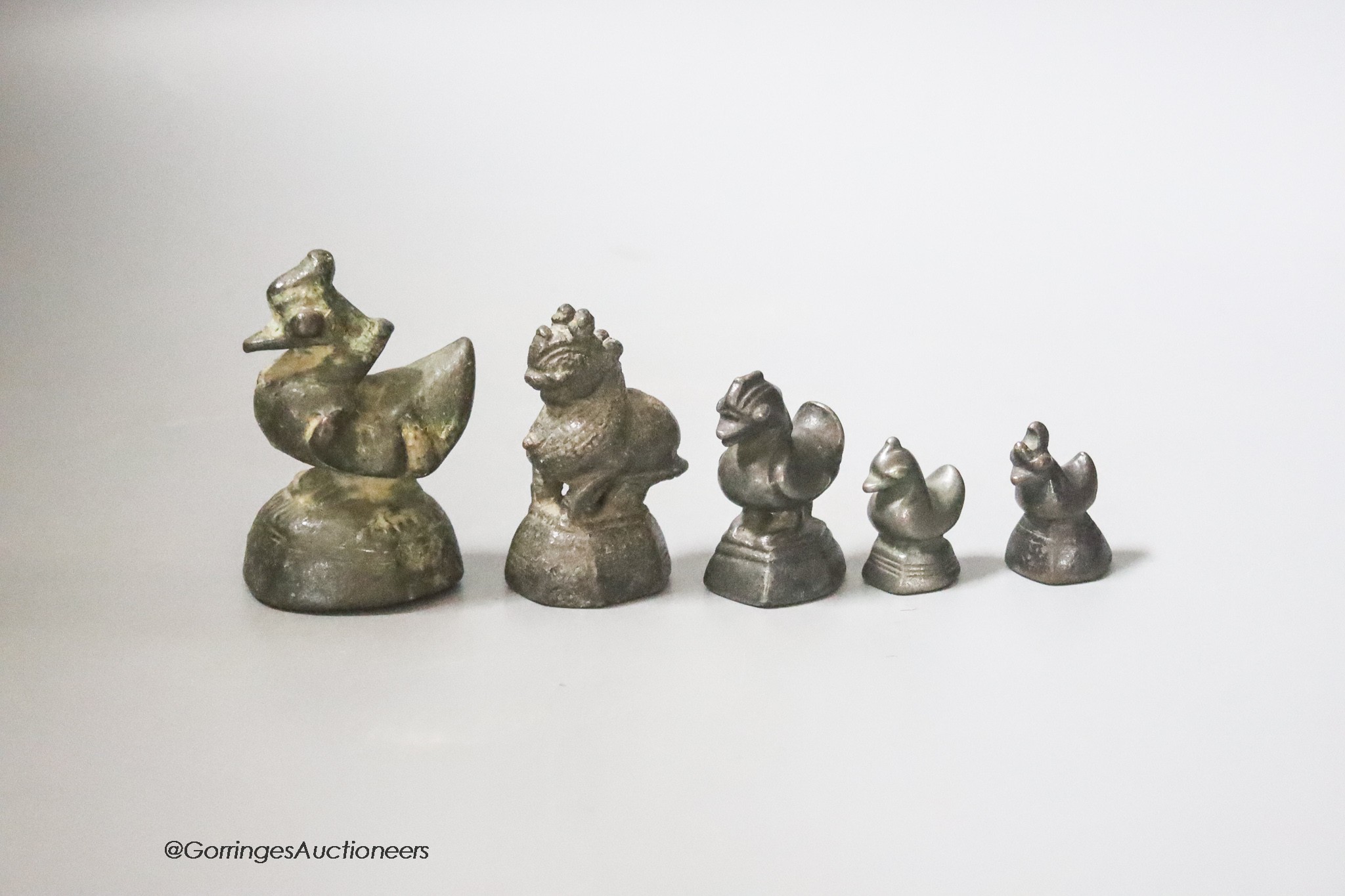 A set of five Burmese bronze opium weights, tallest 6cm